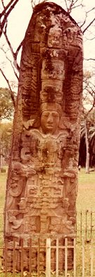 A tall, narrow monument with the prominent sculpture of a king surrounded by elaborate decoration