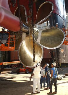 Shipyard employees reattaching the bronze propeller of USS George Washington while in dry dock