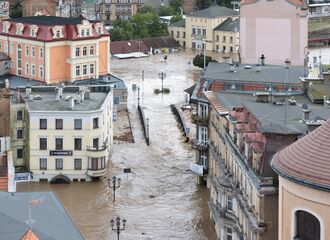 Flooded Iron Bridge in Kłodzko, Poland, surrounded by flooding across multiple buildings