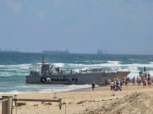 السفينة الامريكية التي علقت على شواطئ أسدود خلال محاولتها استعدة الجزء المنجرف من الرصيف العائم