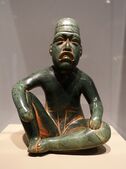 Olmec seated shaman in ritual pose-shaped pendant; 9th-5th century BC; serpentine and cinnabar; height: 18.5 cm; Dallas Museum of Art (Dallas, Texas, USA)[32]
