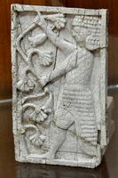 Standing man holding branches of lotus flowers.