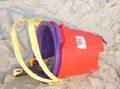 Plastic buckets on a beach, with two shovels