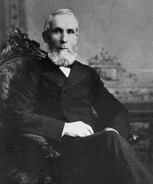 Monochrome photograph of Alexander Mackenzie sitting in a chair