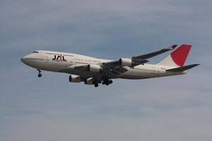 A Boeing 747-400 aircraft in mid air, with greyish blue sky in the background
