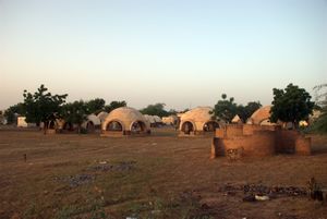 أجنحة فارغة لأقارب المرضى في خلفية الصورة، وهي مفصولة عن المستشفى. إلى اليمين دورات المياه لأقارب المرضى.