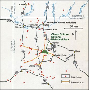 Large square map of northwestern New Mexico and neighboring parts of, clockwise from left, western Arizona, southeastern Utah, and southwestern Colorado. The map region has a green and blocky rectangular-crescent area at its center labeled "Chaco Culture National Historical Park". Radiating from the green region are seven segmented gold lines: "[p]rehistoric roads", each several dozen kilometers in length when measured according to the map scale factor. Roughly seventy red dots mark the location of "Great House[s]"; they are widely spread across the map, many of them far from the green area, near the extremes of the map, more than one hundred kilometers from the green area. Two proceed roughly south, one southwest, one northwest, one straight north, and the last to the southeast. Yellow dots mark the location of modern settlements: "Shiprock", "Cortez", "Farmington", and "Aztec" to the northwest and north; "Nageezi", "Cuba", and "Pueblo Pintado" to the northeast and east; "Grants", "Crownpoint", and "Gallup" to the south and southwest. They are connected by a network of gray lines marking various interstate and state highways. A fan of thin blue lines along the northern margins of the map depict the San Juan River and its communicants.