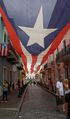 Calle de la Fortaleza leading to the palace with a canopy of the Monoestrellada (Monostarred) flag of Puerto Rico
