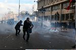 المتظاهرون يفرون من قنابل الغاز المسيلة للدموع التي تستخدمها الشرطة لتفريق المتظاهرين.