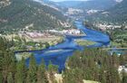 A wide river flows through coniferous forest in a mountain valley