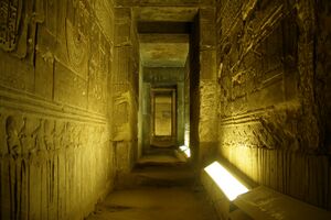 photo of interior of Dendera temple. The temple, dedicated to Hathor, is well preserved. It has a great stone roof and columns, dark chambers, underground crypts, and twisting stairways, all carved with hieroglyphs.