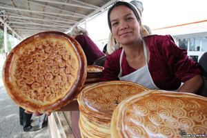 سيدة اوزبكية تحمل خبز الباتير في مدينة كوكاند، مارس 2013.jpg