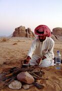 A young Bedouin lighting a camp fire in Wadi Rum, Jordan.