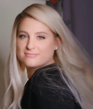 Meghan Trainor, a woman, smiling and looking towards the screen
