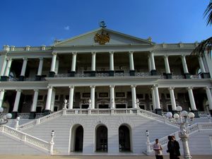 A balck and white building with garden in front.