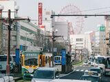 Kajiyachō Tram Stop with its back to the Kagoshima-Chūō Station Building having Ferris wheel