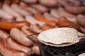 A scallop being grilled next to sausages at a yatai in Japan