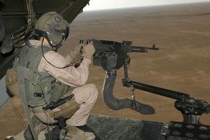 M240 machine gun mounted on V-22 loading ramp with a view of Iraq landscape with the aircraft in flight.