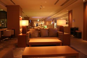 A three seater couch with two coffee tables in the front and two side tables on both side, all in neutral brown colour