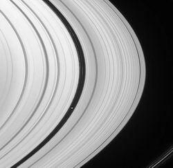 بان، قمر زحل، يبلغ متوسط نصف قطره 9 أميال تقريبًا، ويُشبه بالرافيولي أو الزلابية.