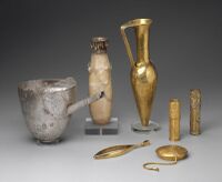 Artifacts including large metal tweezers, decorated and inscribed vessels, gold sheaths, and a ewer marked for King Aspelta found in Nuri pyramid 8. Museum of Fine Arts, Boston.