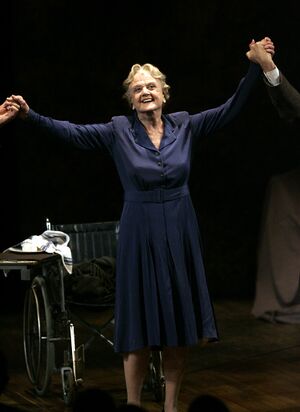 An elderly woman with her arms held aloft