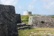 The evolution of coastal fortification design, between the 1790s and 1822, can be discerned between Ferry Island Fort (in the foreground), with multiple guns arrayed to cover the water westward, and the Martello tower in the background, which used a single gun with 360° traverse to cover the area.