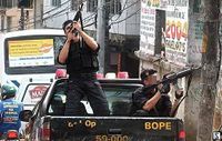In earlier days the SWAT squad BOPE(Rio de Janeiro) appeared to be locked in a civil war with the city's drug gangs (left). During the 1992 Carandiru prison (pictured) rebellion 111 inmates were killed by the police, leading to the founding of the criminal organization Primeiro Comando da Capital(right)